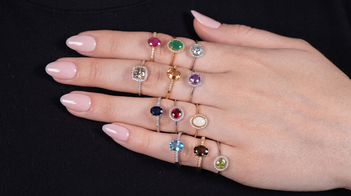 Multicolor gemstone rings in emerald, ruby and sapphire on a hand