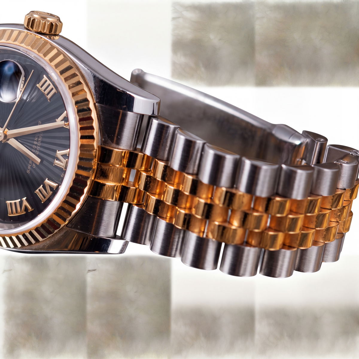 Close-up of a two-tone steel and gold watch bracelet with fluted bezel