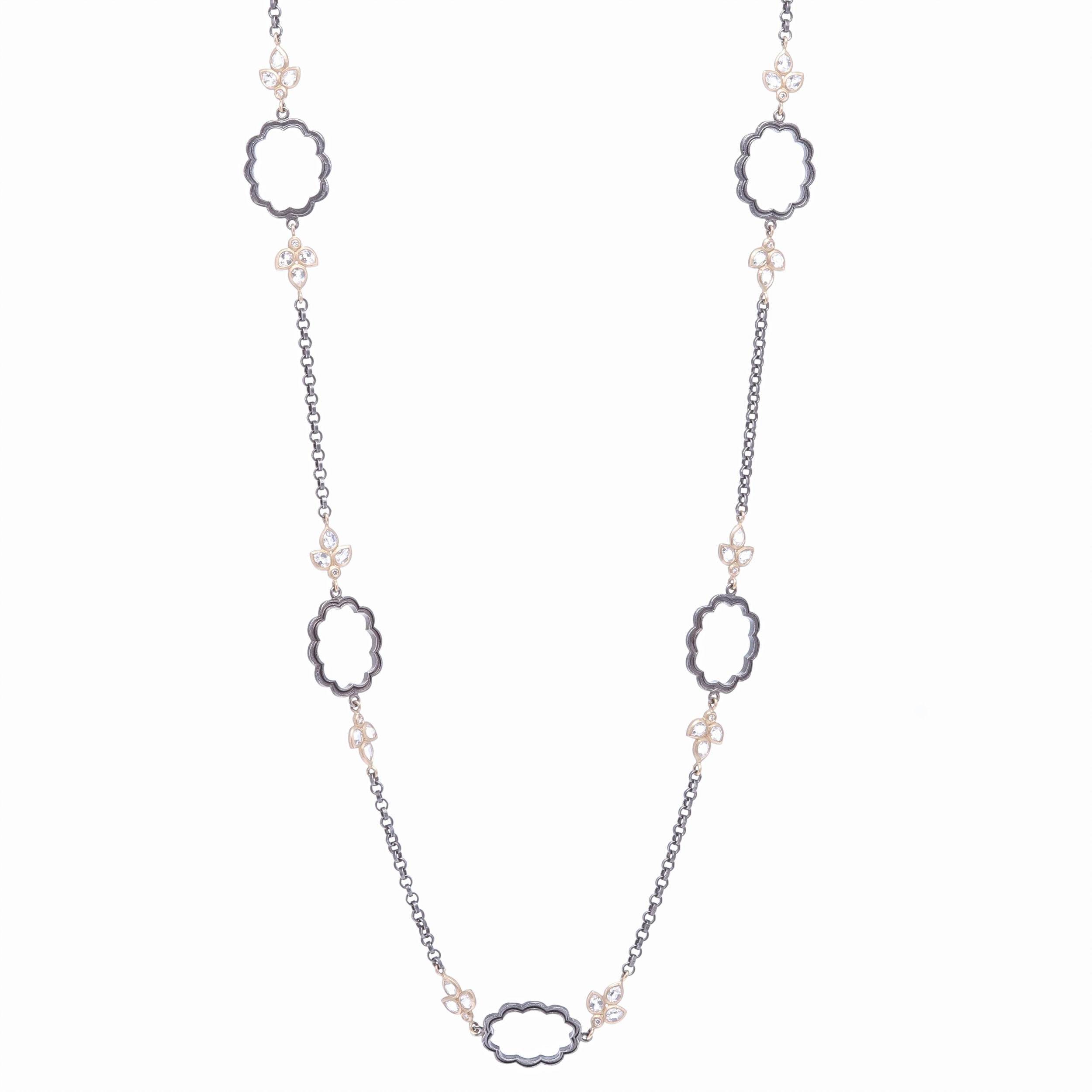 Handcrafted in rhodium sterling, this decorative floral chain makes quite the statement. The buds consist of three rose cut topaz and one diamond set in 14k yellow gold. Total gold weight 9.26g, White topaz 3.27ct, and Diamond 0.14ct. Scalloped Floral Leaf Chain