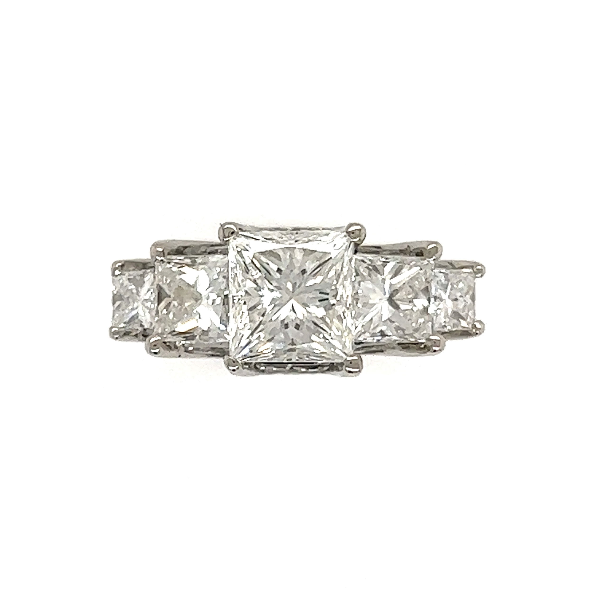 This beautiful ring is perfect for the special someone in your life. It's crafted in pure platinum and set with a stunning 1.52ct princess cut diamond of G-VS1 clarity and GIA certified (#5221303518). The diamond is surrounded by four quad cut princess diamonds, totaling 1.26tcw, and sixteen straight and tapered baguette diamonds, totaling .73tcw. The ring has a total diamond weight of 1.99tcw and weighs 9.1g. Its elegant design is sure to make a statement and capture the heart of your special someone. Platinum 1.52ct Princess Cut Diamond G-VS1 GIA & 1.99tcw Diamond Ring 9.1g, s5