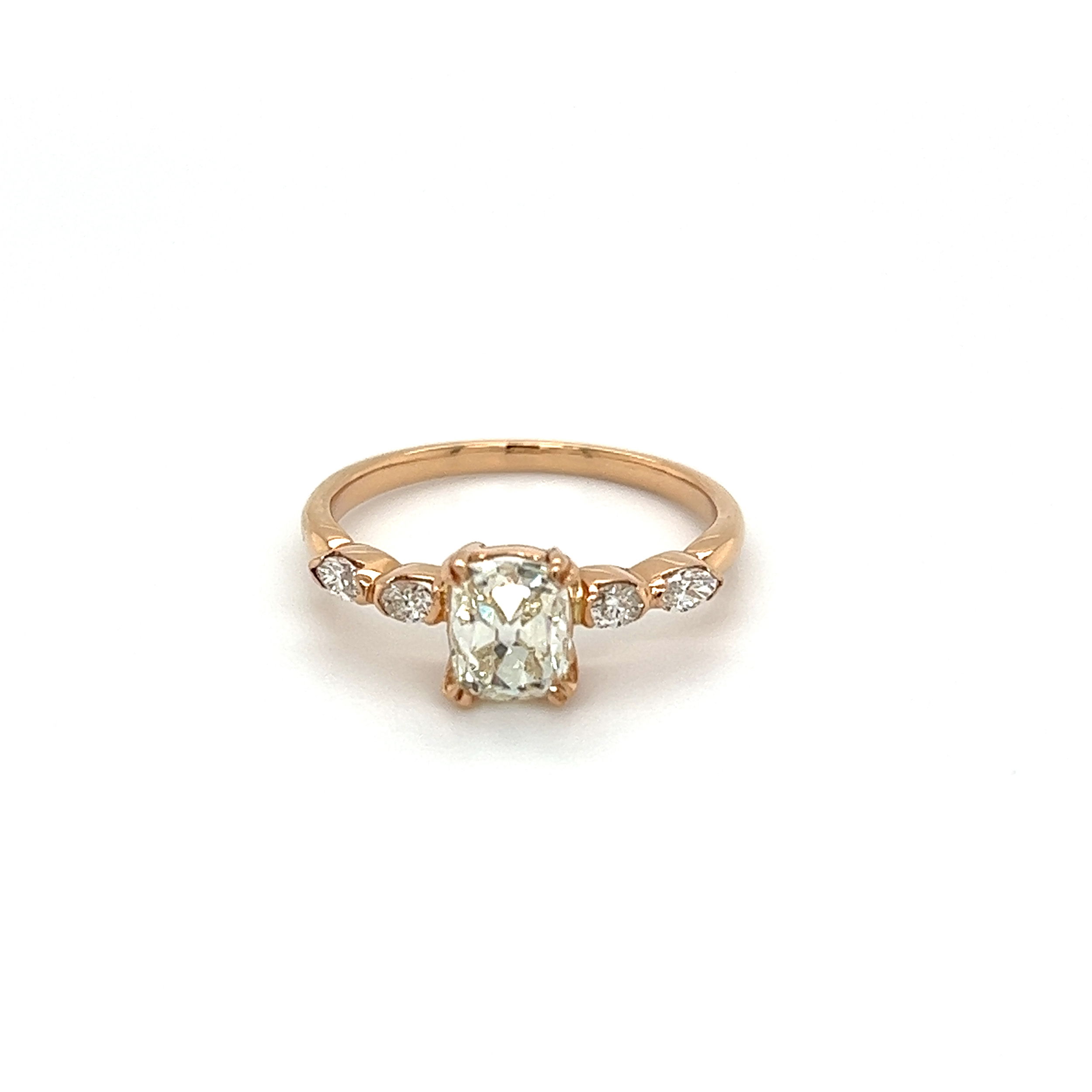 This 18K rose gold diamond estate ring is a one-of-a-kind piece that will take her breath away. Featuring a stunning 1.18ct old mine cushion cut diamond with a gorgeous L/VS2 clarity and four marquis diamonds surrounding it and totaling 0.20ctw with an H-VS2 clarity. The ring comes in a size 7.5 and weighs 2.7g. From day to night, this ring is perfect for any occasion. Show her your love with this classic and timeless ring. 18K RG 1.18ct Old Mine Cushion Diamond & .20tcw Marquis Diamond Ring 2.7g, s7.5