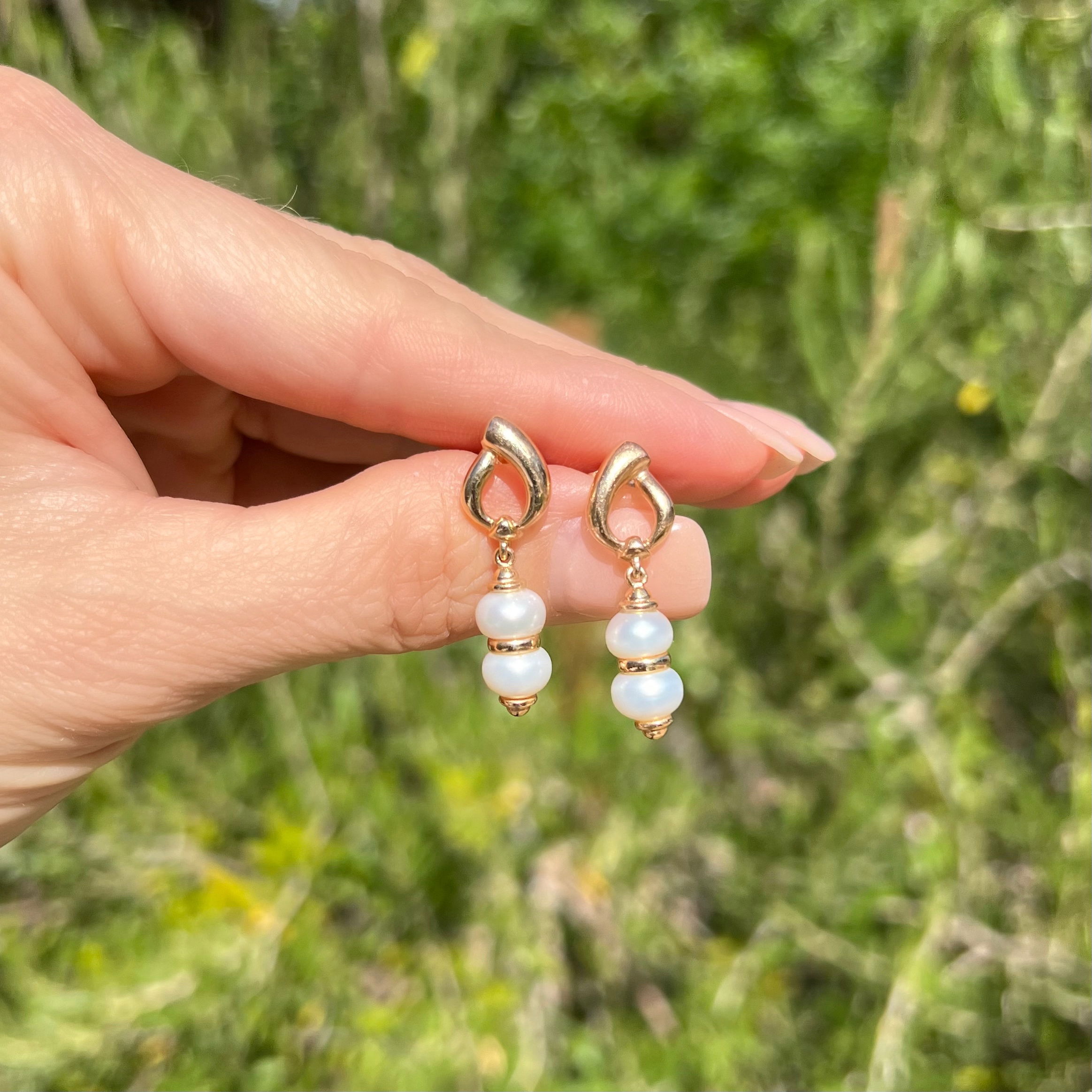 These luxurious 14K Yellow Gold Open Top Double Pearl Drop Earrings will make a statement in any setting. Each earring is crafted from 5.7g of solid yellow gold with a classic open top design and two lustrous freshwater pearls. Measuring 32mm in length, these earrings are perfect for any special occasion and will make a timeless estate piece. 14K YG Open Top Double Pearl Drop Earrings 5.7g, 32mm