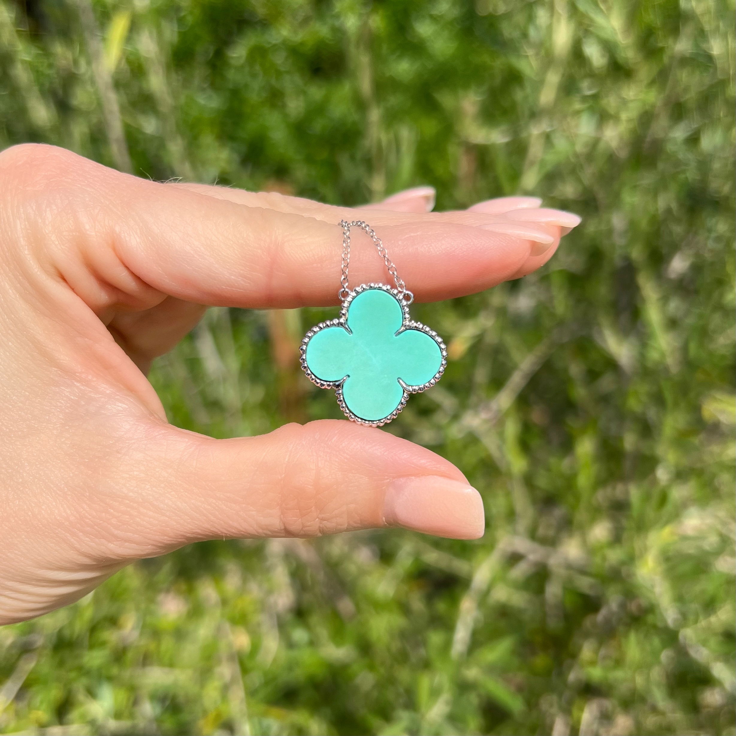 This exquisite 18K White Gold 1" Flat Turquoise Alhambra Pendant Necklace is a stunning piece of jewelry that is perfect for any special occasion. It features a beautiful turquoise encased in a delicately-crafted 18K white gold frame. The necklace measures 18" and weighs 6.4 grams for a comfortable yet noticeable feel. It is an heirloom-quality piece that will be sure to make anyone who wears it feel beautiful and special. With its eye-catching design and top-quality materials, this necklace is a must-have for anyone looking for a truly unique and breathtaking piece of jewelry. 18K WG 1" Flat Turquoise Alhambra Pendant Necklace 6.4g, 18"