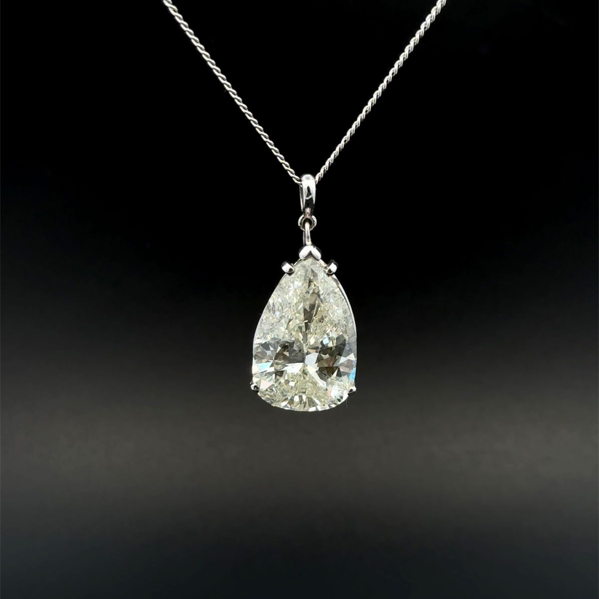 A pear-shape diamond solitaire pendant on a white gold chain