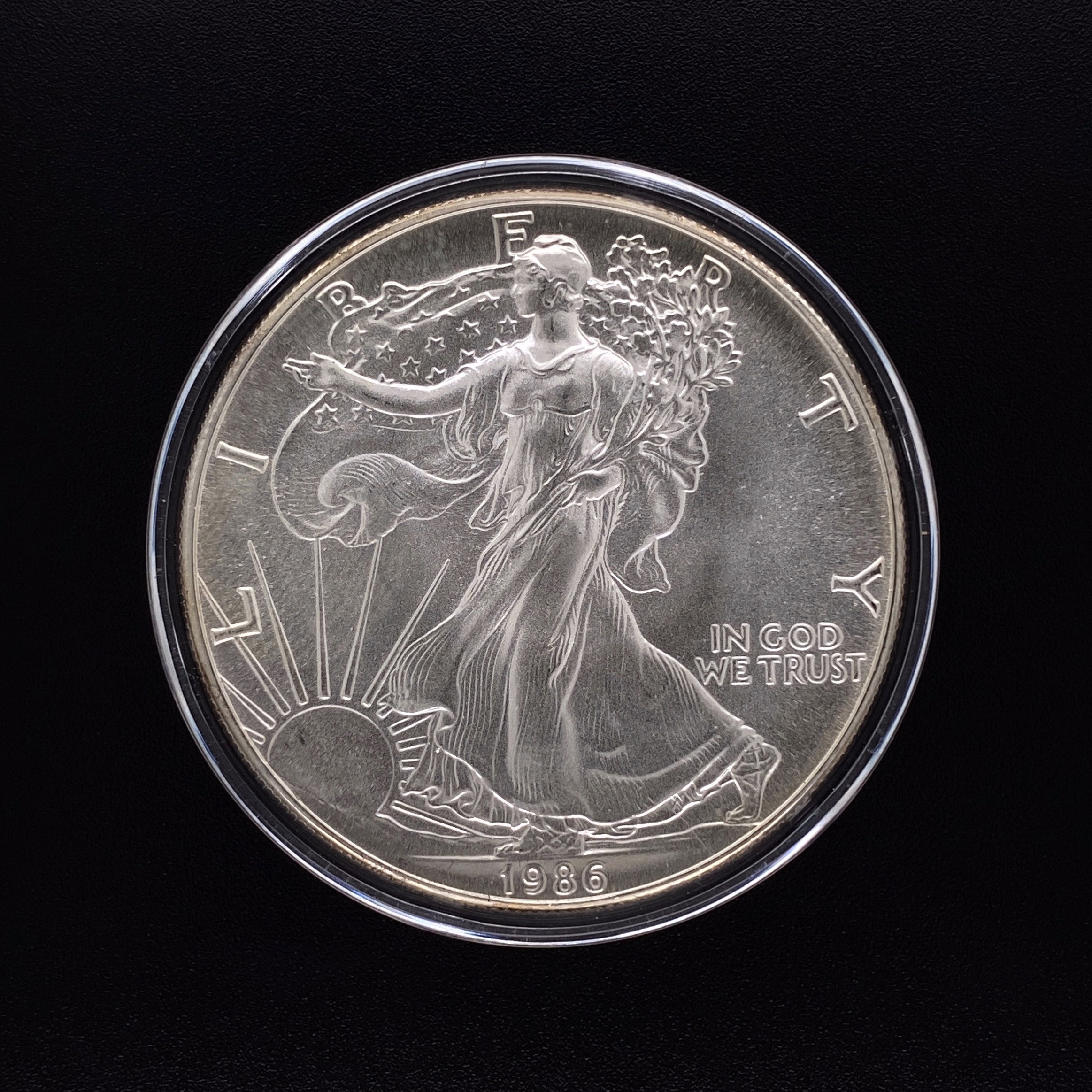 In 1986 the United States began striking the modern American Silver Eagle coin. The coin’s obverse design is patterned after Adolph A. Weinman’s (1870-1952) design of the Walking Liberty Half Dollar, used between 1916-1947. The reverse depicts the classic bald eagle, America’s classic symbol for liberty and freedom. 1986 United States Silver Eagle Coin MINT 1oz Pure