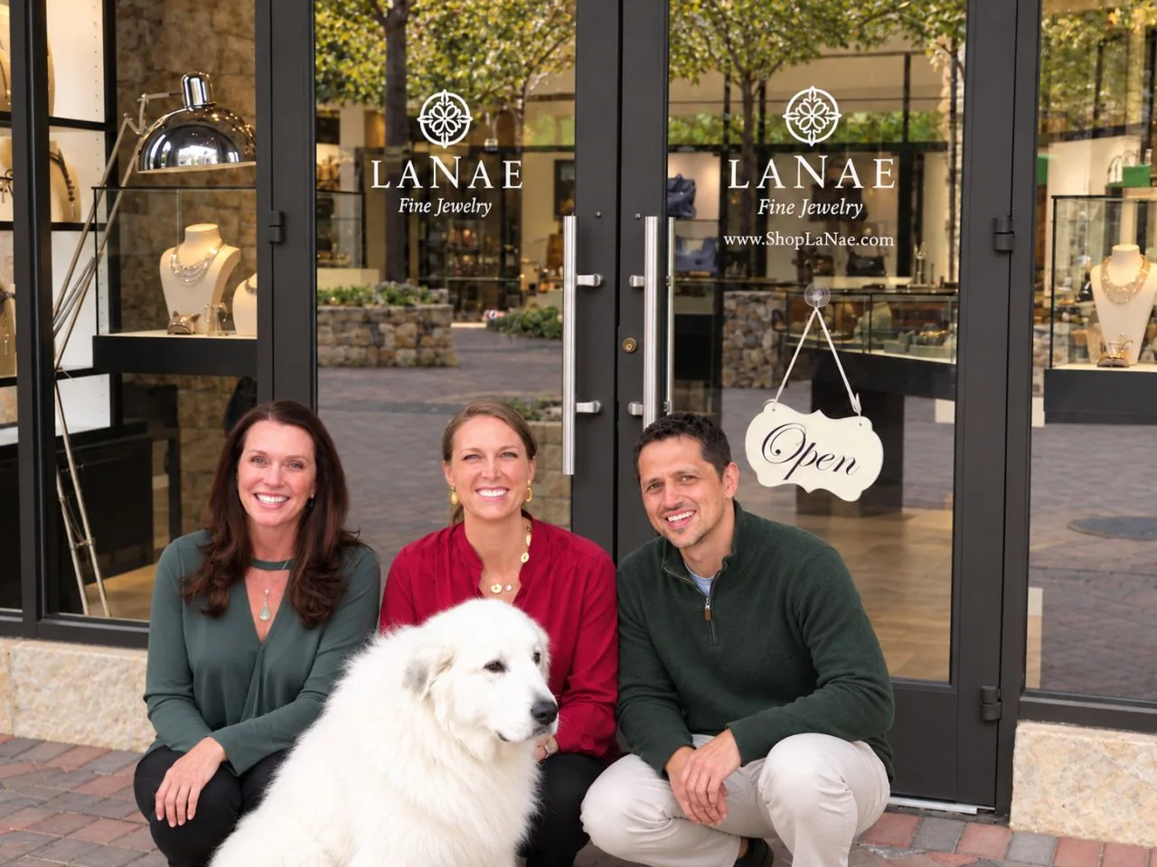Cherish, Gert and Cassie with a white dog outside the LaNae Fine Jewelry storefront