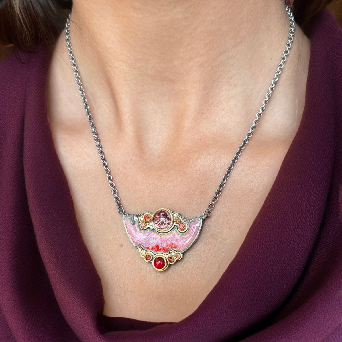 Cowl-neck top styled with a bold pendant necklace that stands out against the drape.