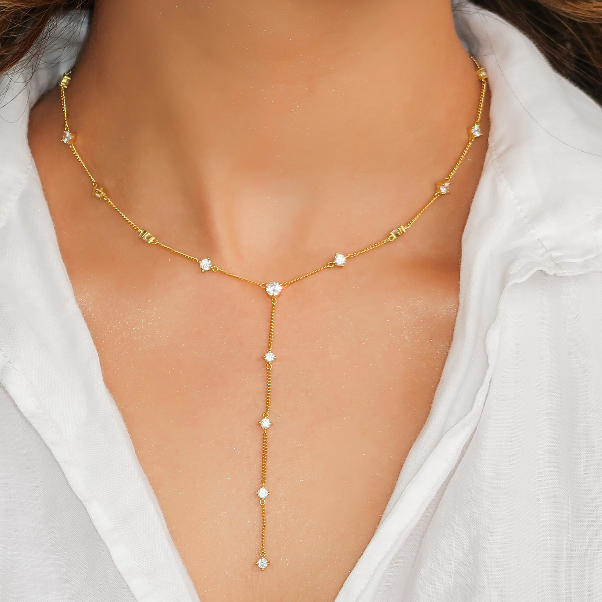 Dramatic plunging neckline paired with a long lariat necklace for maximum visual impact.
