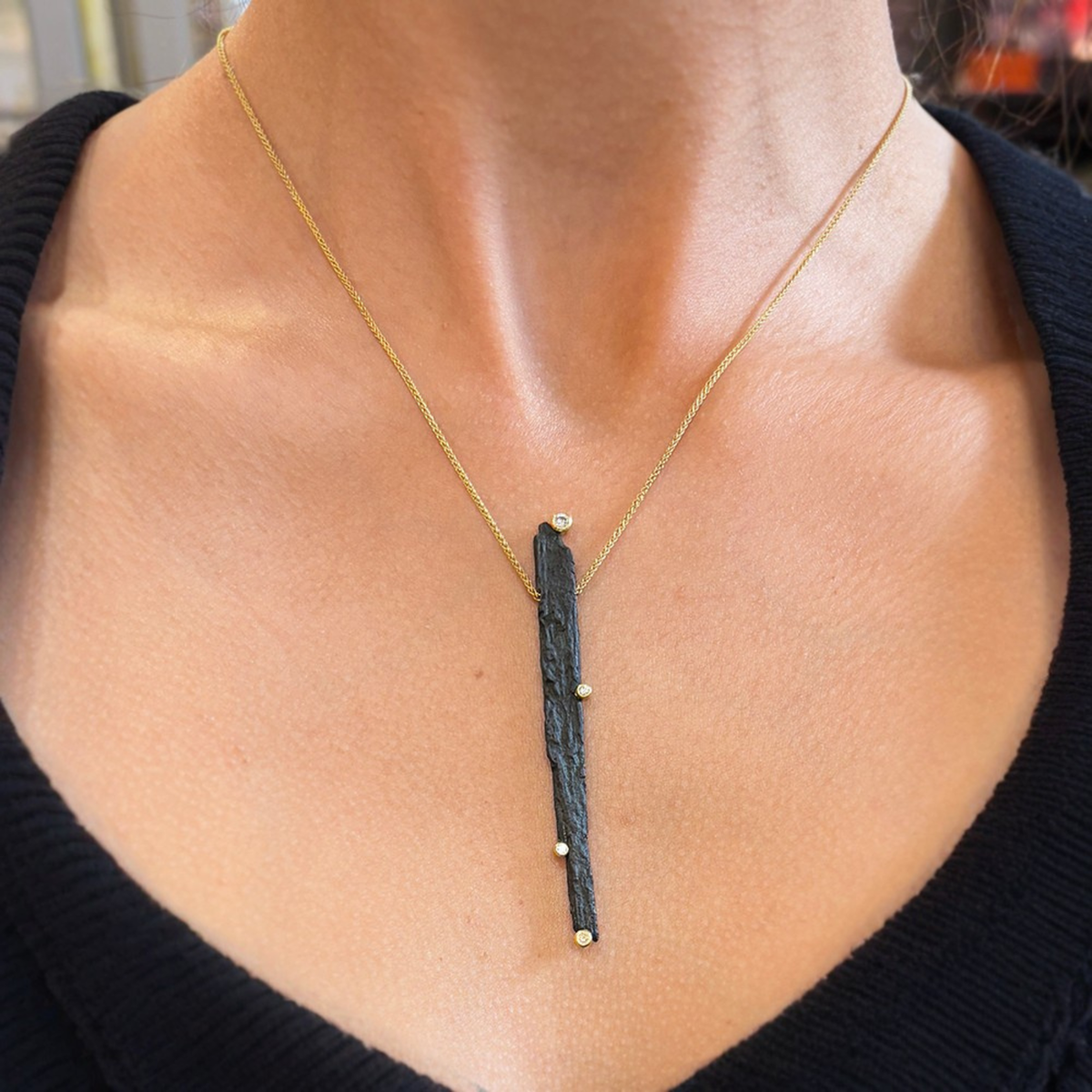 V-neckline paired with a pendant necklace that mirrors the shape of the neckline.