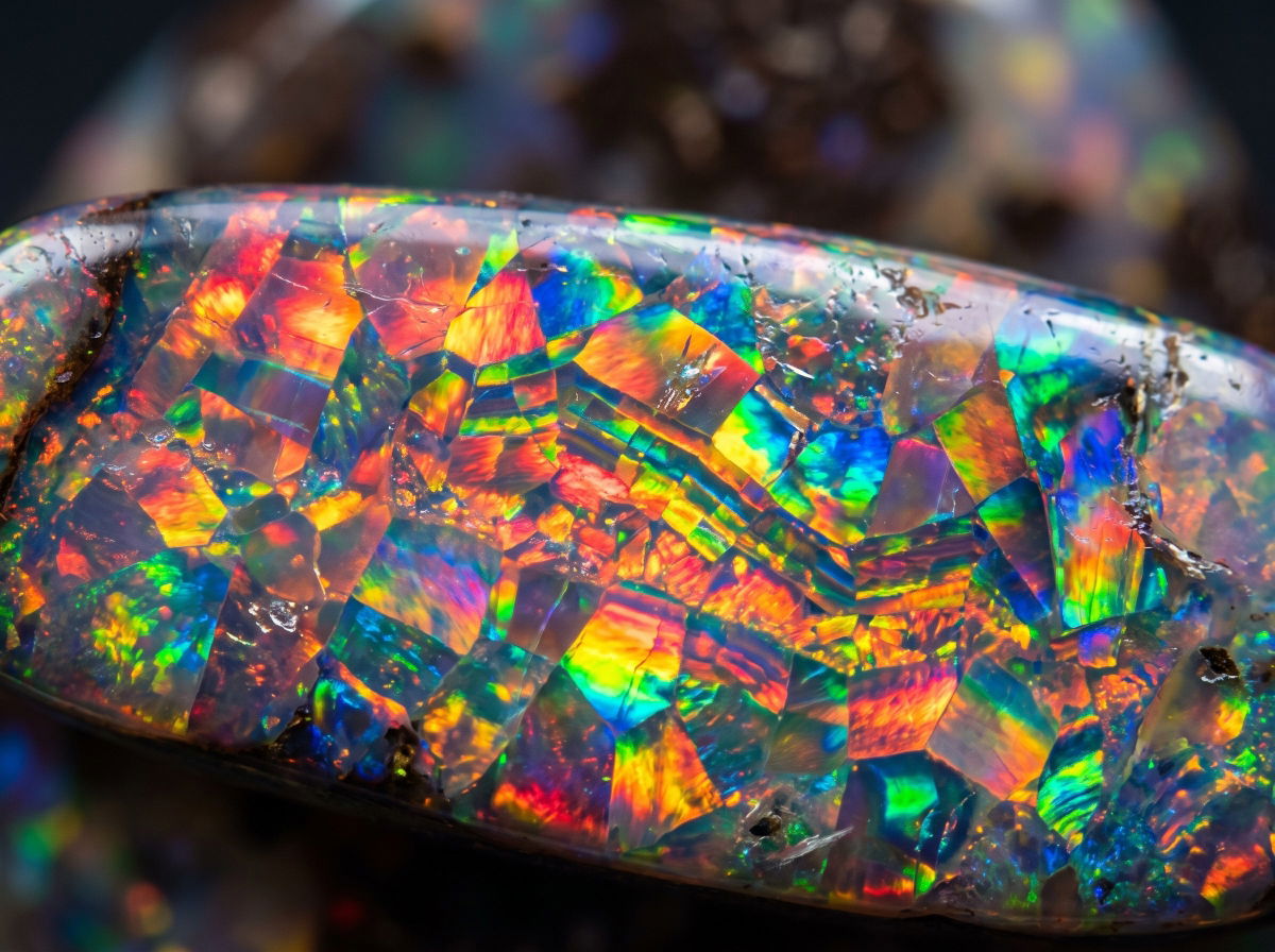 Macro detail of an opal's play-of-color showing its layered silica structure.