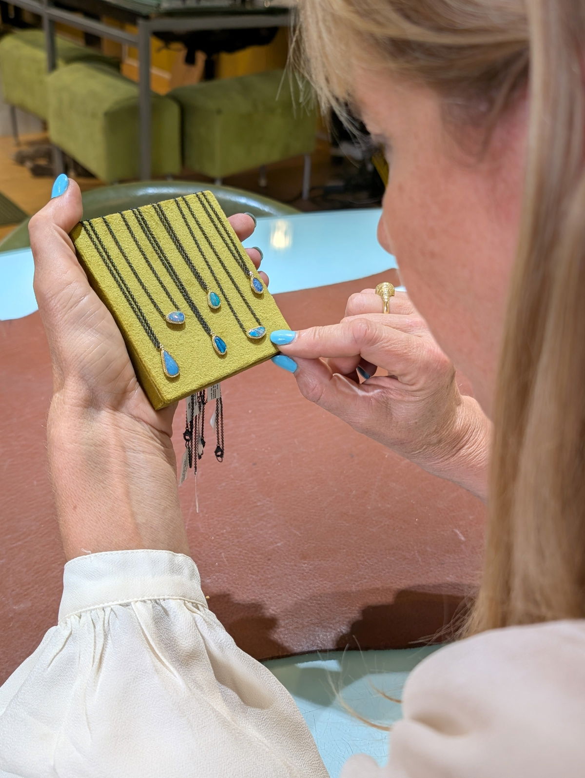 Alara Jewelry team member inspecting opal pieces at the Bozeman, Montana showroom.