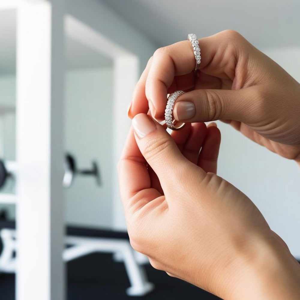 Hands taking off rings for safety before a workout