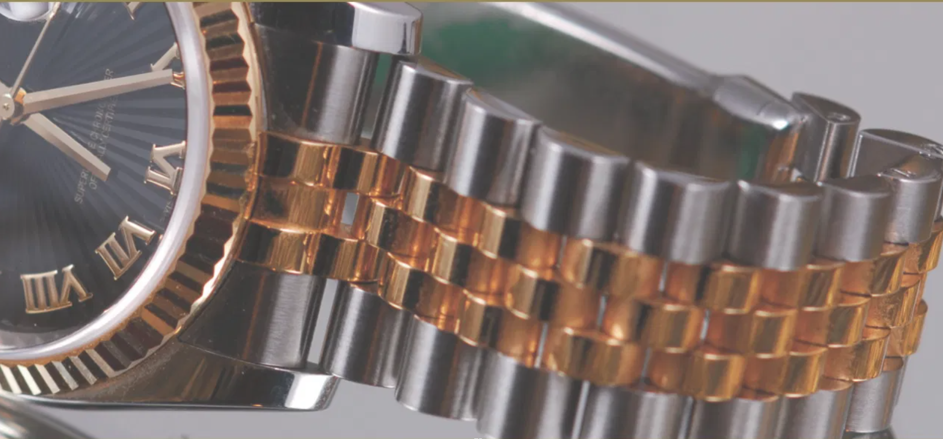 Close-up of a two-tone steel and gold watch bracelet with jubilee links