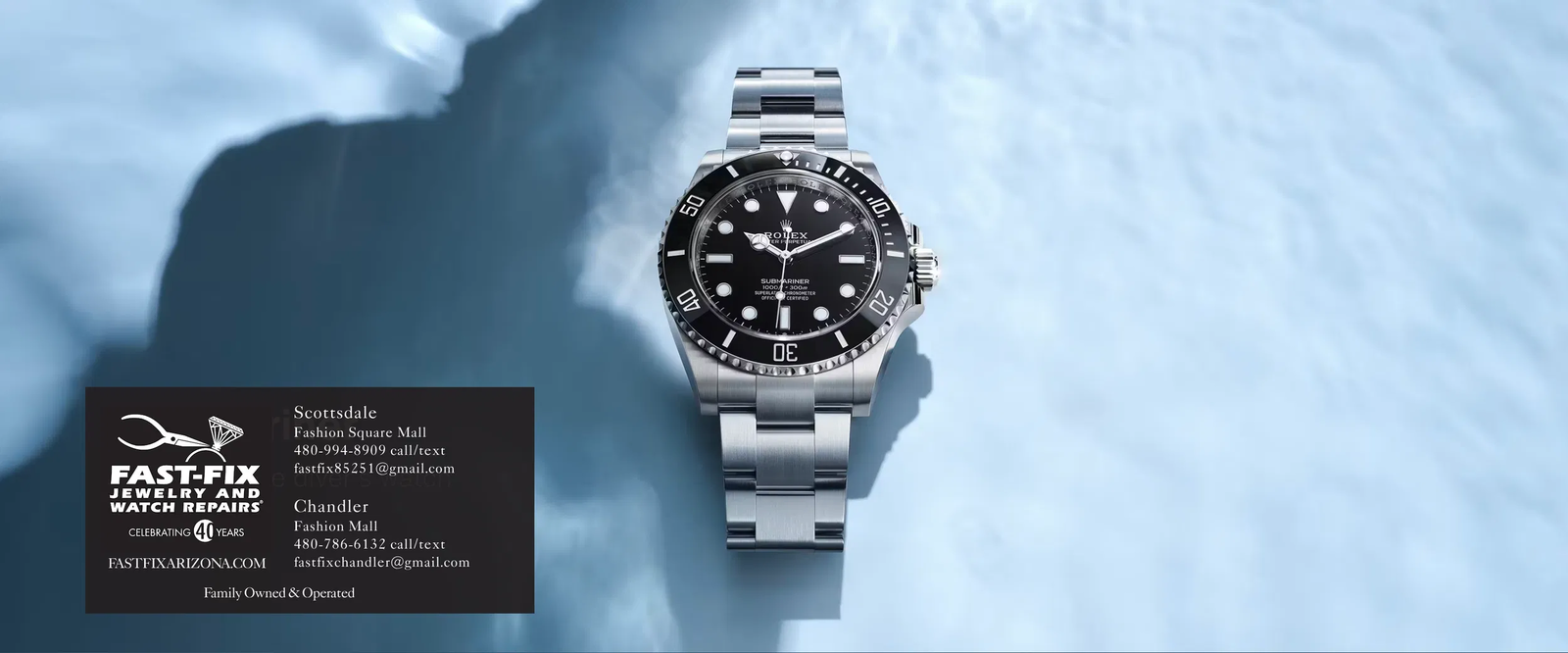 Luxury dive watch with a green bezel resting on a dark textured surface