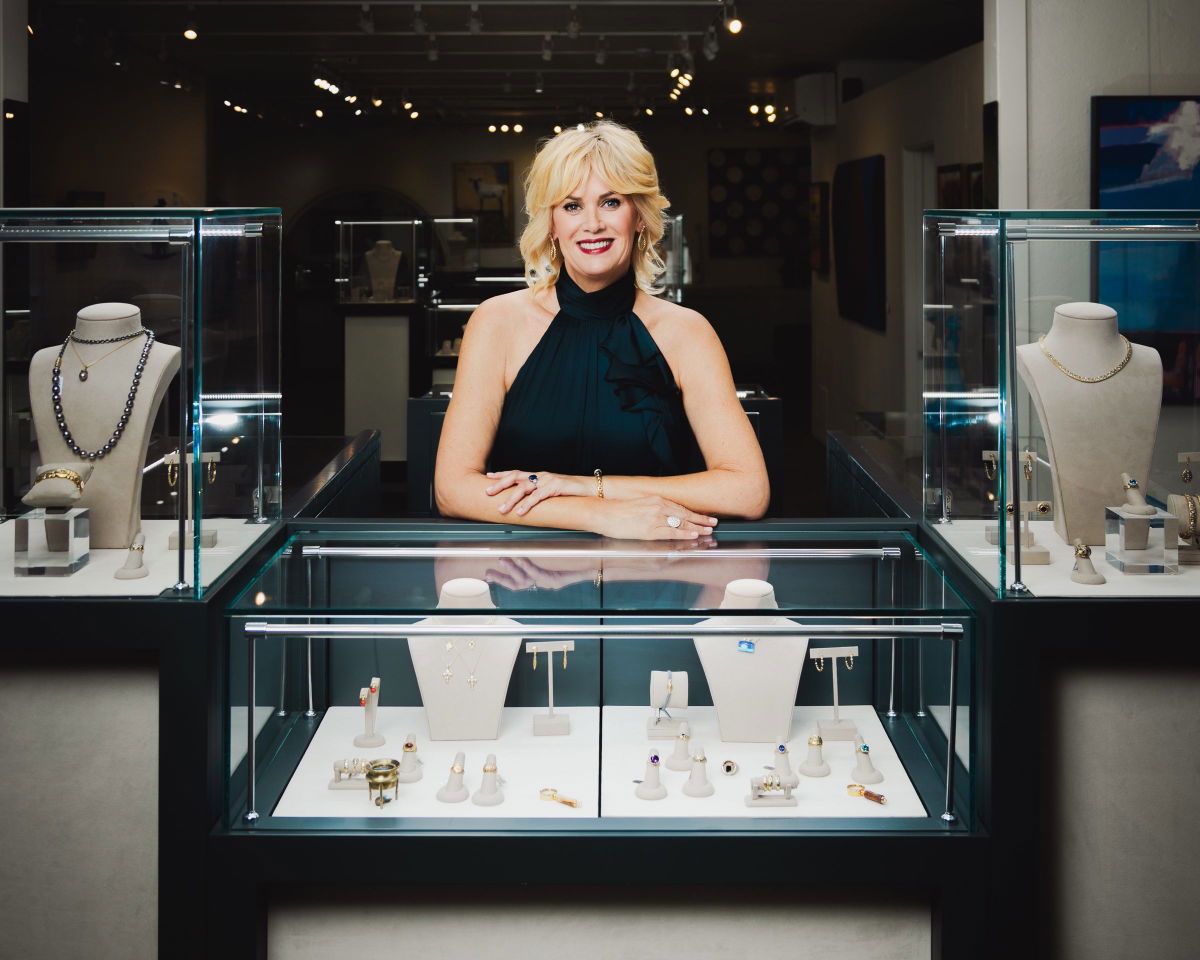 Shelly, founder of Grace Renee Gallery, behind a jewelry case in the gallery