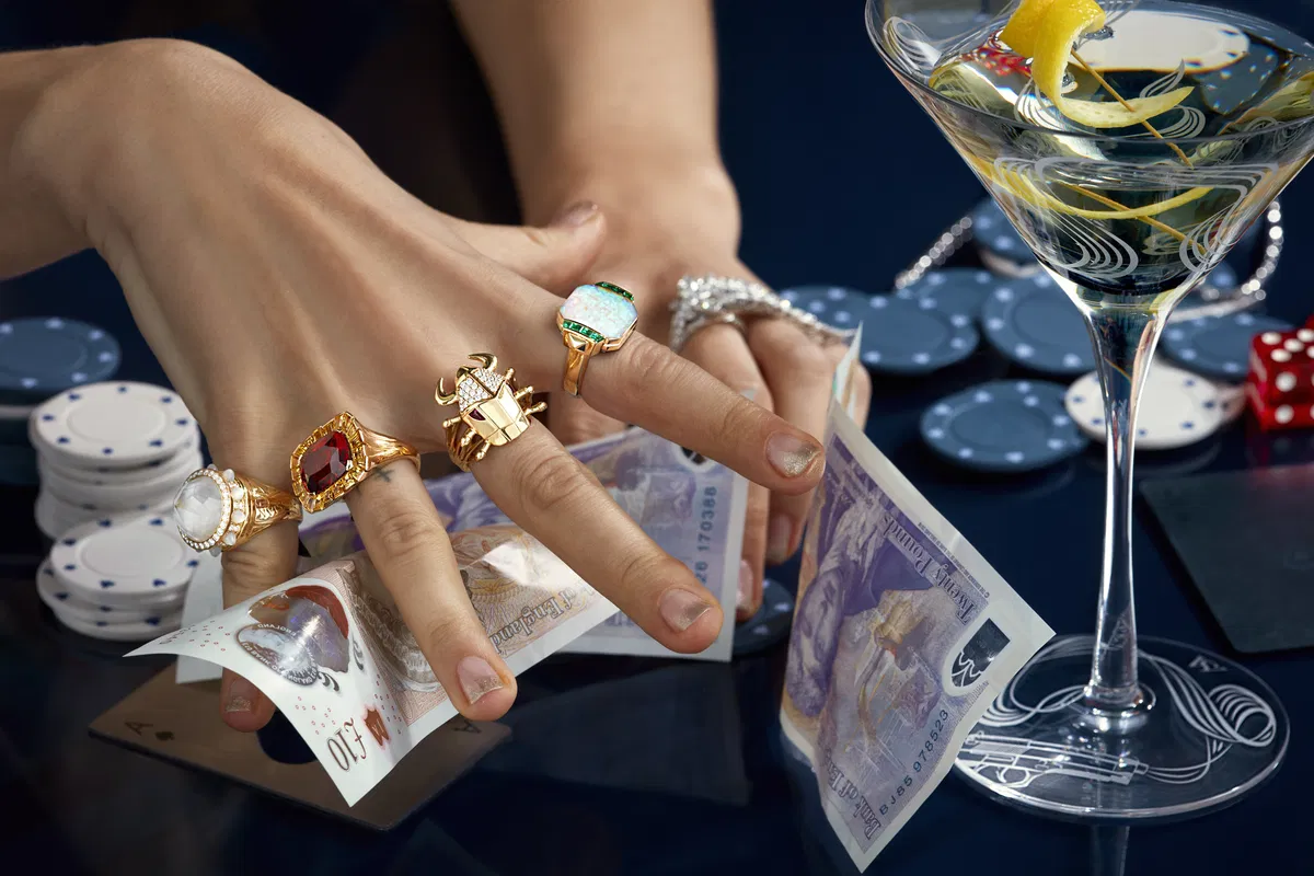 Stephen Webster gold statement rings with casino chips and a martini