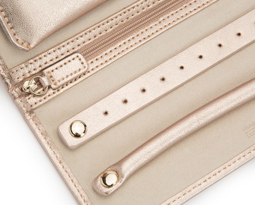 Palermo Jewelry Roll Rose Gold by WOLF 1834 - Charming and sophisticated, Palermo takes cues from its namesake city on the side of a mountain by the sea. Perfect for travel, the sumptuous leather exterior and classic gold hardware provide an elegant and practical way to store your best pieces while on-the-go. Includes LusterLoc™ anti-tarnish lining and gold finish. Storage: 1 ring roll, 13 earring holes, 6 necklace holders, 2 storage compartments (1 removable). LusterLoc: Allows the fabric lining the inside of your jewelry cases to absorb the hostile gases known to cause tarnishing. Under typical storage conditions, it can prevent tarnishing for up to 35 years. SIZE: 9.25" L X 4.25" W X 1.5" H Palermo Jewelry Roll in Rose Gold