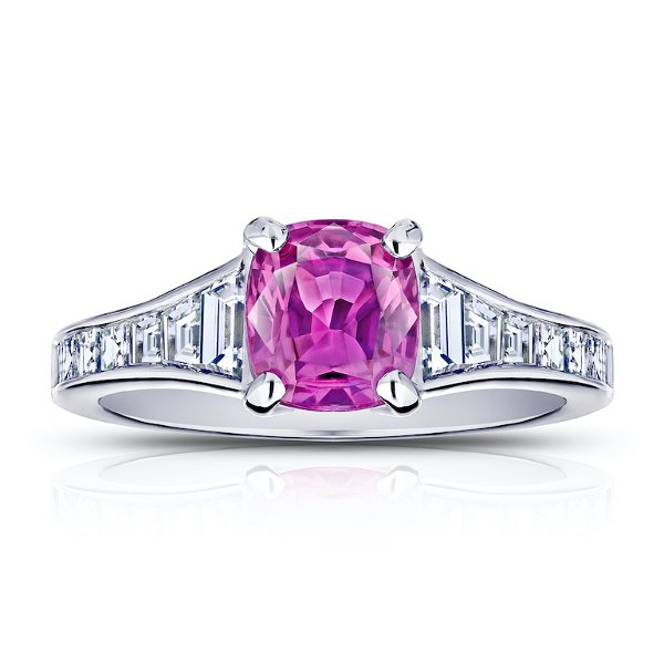Closeup photo of 1.38 carat cushion pink sapphire with 14 trapezoid and carre diamonds .84 carats channel set in a platinum ring