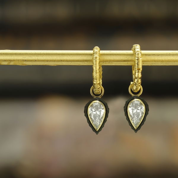 Closeup photo of Chroma Hoop Earrings with White Pear Diamond Dangles in 18kt Yellow Gold and Black Chrome