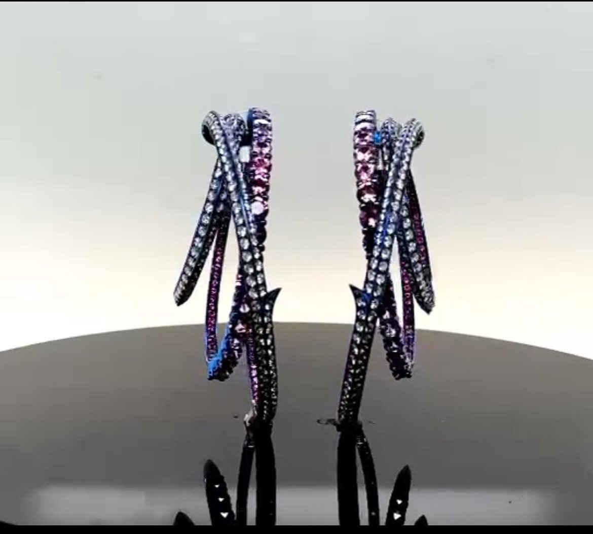 Thorn Embrace Unraveled Hoop Earrings with Light Pink Sapphires and White Diamonds in Blue Titanium by Stephen Webster. Dangerously alluring; the Unraveled Hoop Earrings are innovatively crafted in lightweight electric blue Titanium and set with oval faceted light pink Sapphires and White Diamond pave. There are 5.56ctw of white diamonds and 10.87ctw of light pink sapphires. Thorn Embrace Unraveled Hoop Earrings with Light Pink Sapphires and White Diamonds in Blue Titanium