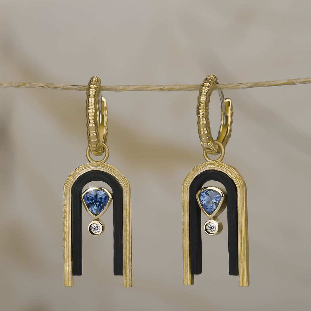 Paramount Arch Hoop Earrings with Teal Sapphire in Black Chrome and 18kt Yellow Gold by Sarah Graham.? Hoop earrings with Arch dangle set with 0.57ctw teal blue sapphires in oxidized cobalt chrome and 18kt yellow gold.?? Paramount Arch Hoop Earrings with Teal Sapphire in Black Chrome and 18kt Yellow Gold