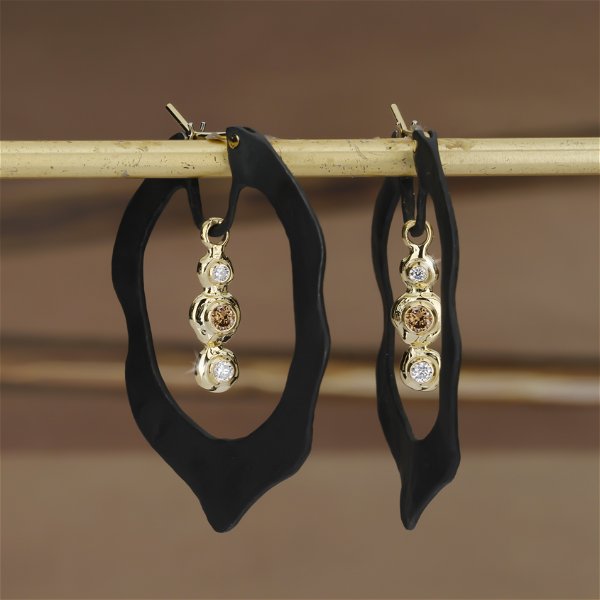 Closeup photo of Jacaranda Dangle Hoop Earrings with White and Cognac Diamonds in Black Chrome and 18kt Yellow Gold