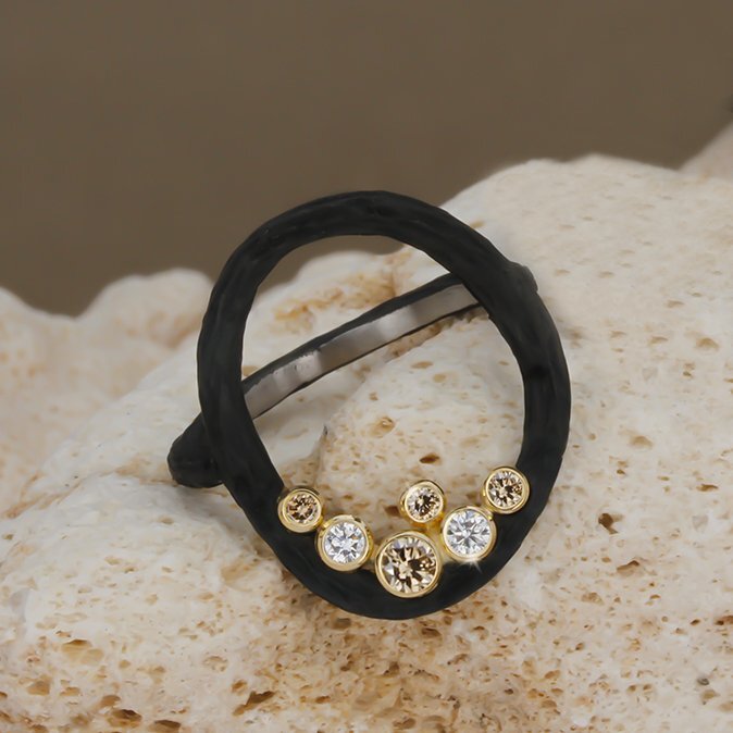 Pebble Large Circle Ring with White and Cognac Diamonds in Black Chrome and 18kt Yellow Gold by Sarah Graham. Open circle ring in oxidized cobalt chrome with 0.34ctw white and cognac diamonds bezel set in 18kt yellow gold.? This ring is a size 6.5. Pebble Large Circle Ring with White and Cognac Diamonds in Black Chrome and 18kt Yellow Gold - Size 6.5