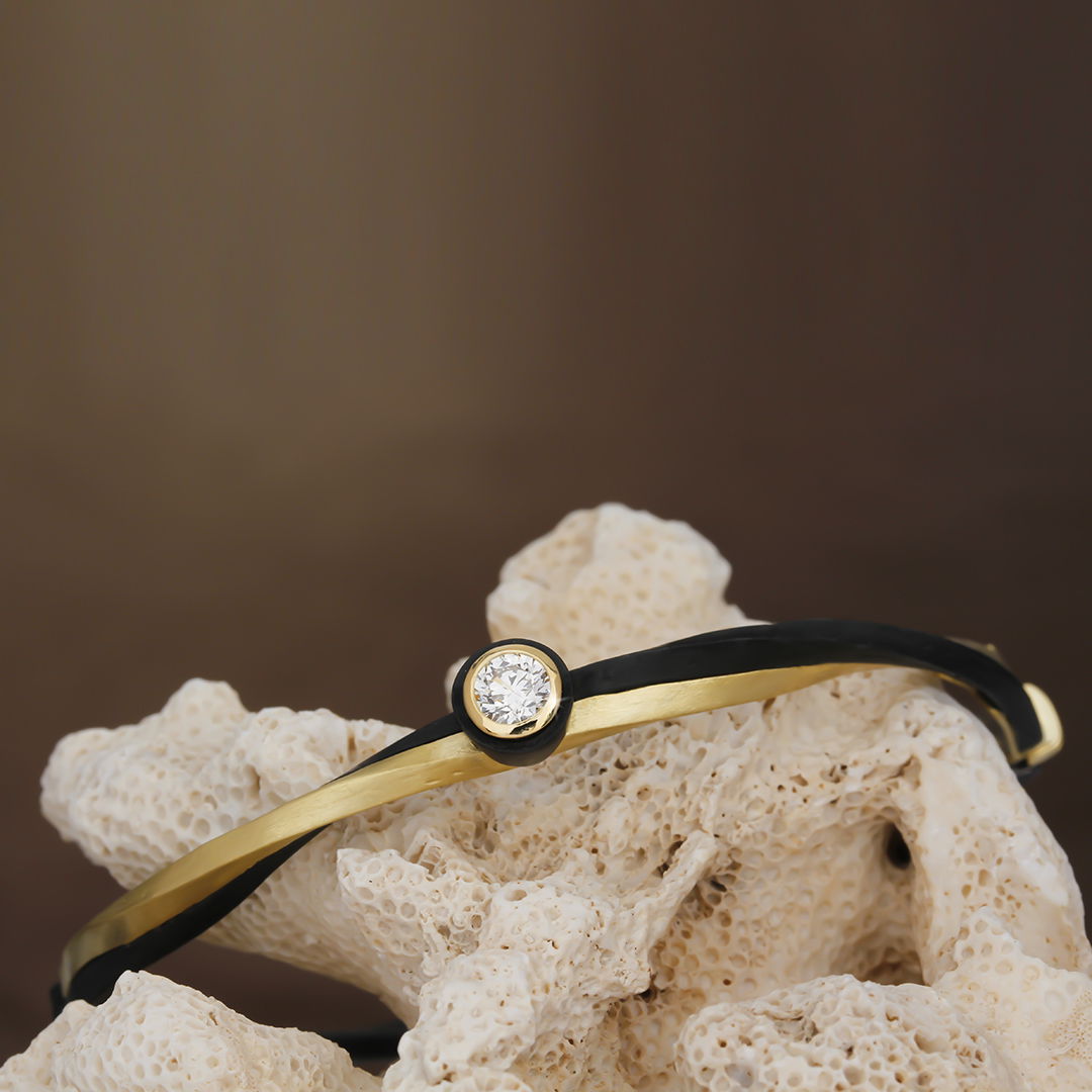 Eclipse Hinged Cuff Bracelet with White Diamond in 18kt Yellow Gold and Black Chrome by Sarah Graham. Hinged bracelet with one 0.40ct white diamond bezel set at the top with twisted 18kt yellow gold and oxidized cobalt chrome at the top of the bracelet. Eclipse Hinged Cuff Bracelet with White Diamond in 18kt Yellow Gold and Black Chrome