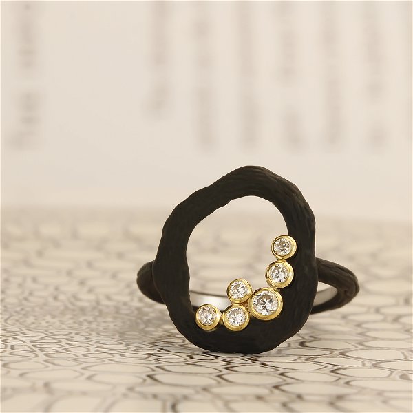 Closeup photo of Pebble Medium Circle Ring with White and Cognac Diamonds in 18kt Yellow Gold and Black Chrome