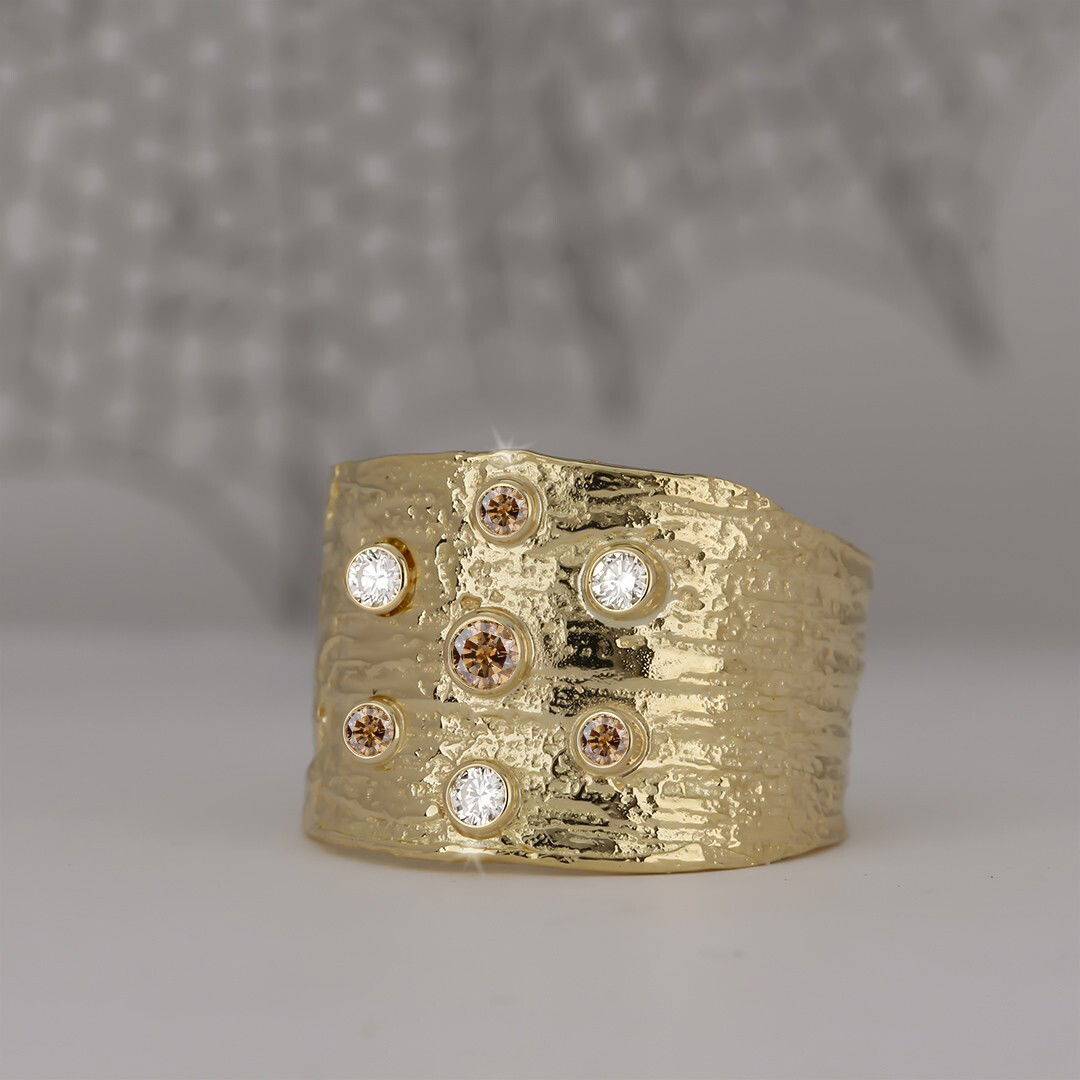 Manzanita Cigar Band Ring with Cognac and White Diamonds in 18kt Yellow Gold by Sarah Graham. Wide cigar band in 18kt yellow gold tapering at the back of the finger. A scattering of cognac and white diamonds at 0.14ctw bezel set into the top of the ring. This ring is a size 7.5. Manzanita Cigar Band Ring with Cognac and White Diamonds in 18kt Yellow Gold