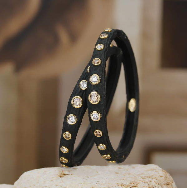 Closeup photo of Pebble 44mm Bold Hinged Hoop Earrings with Cognac and White Diamonds in Black Chrome and 18kt Yellow Gold