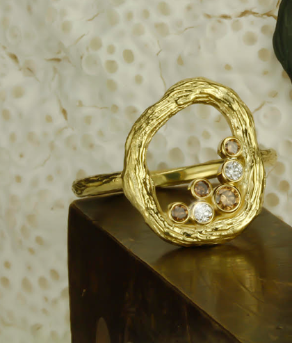 Pebble Small Circle Ring with Cognac and White Diamonds in 18kt Yellow Gold by Sarah Graham. Open oval design with bezel set cognac and white diamonds at 0.17ctw clustered at the bottom of the design. This ring is a size 7. Pebble Small Circle Ring with Cognac and White Diamonds in 18kt Yellow Gold