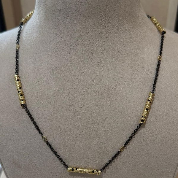 Aspen Station Necklace with White Diamonds in 18kt Yellow Gold and Sterling Silver by Sarah Graham.  Five 18kt yellow gold Aspen motif stations with white diamond stations in between on an oxidized sterling silver chain of 18 inches long.  There are 0.20ctw of white diamonds in the necklace.   Closeup photo of Aspen Station Necklace with White Diamonds in 18kt Yellow Gold and Sterling Silver