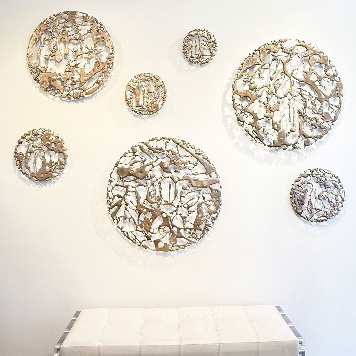 The Gravity Between Us Installation by Jennyfer Stratman - Seven bronze disks measuring from 8 inches in diameter to 27.5 inches in diameter. The Gravity Between Us Installation