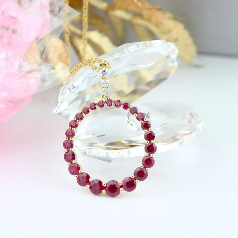 A circular pendant of red gemstones on a gold chain