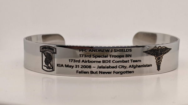 Silver cuff bracelet engraved with a memorial inscription