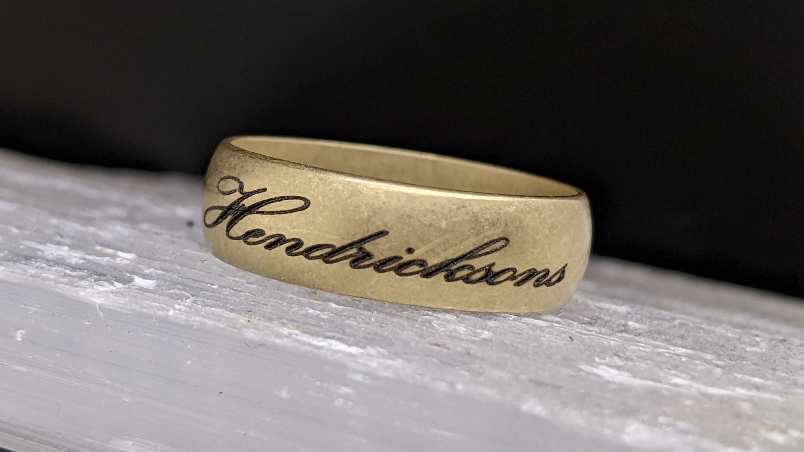 Gold band engraved with a flowing Hendrickson's script signature