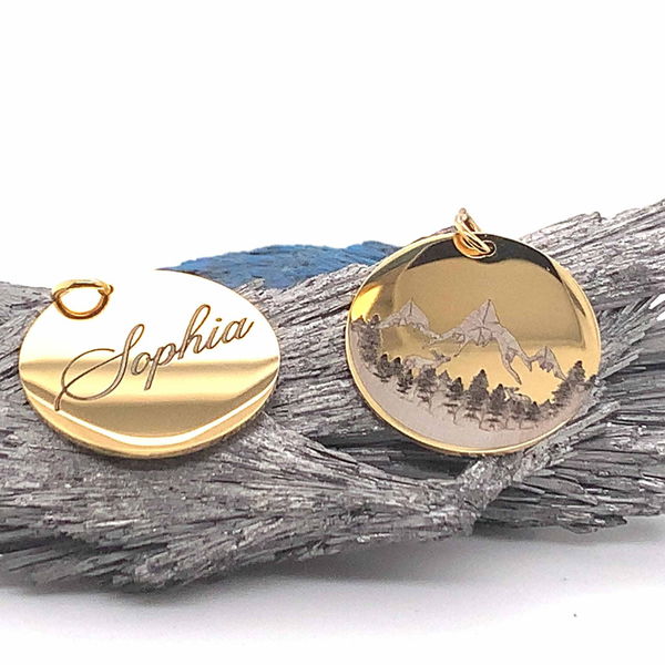 Gold pendants engraved with a name and a mountain scene