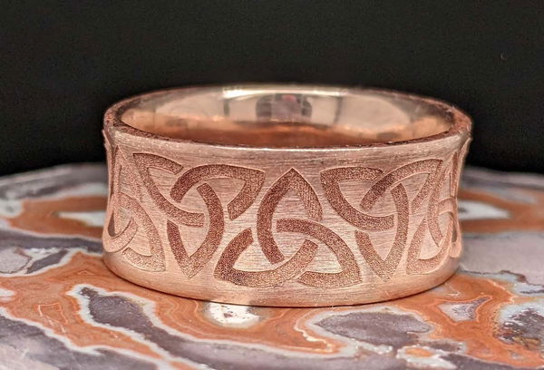 White gold band engraved with a tree line and set with a diamond