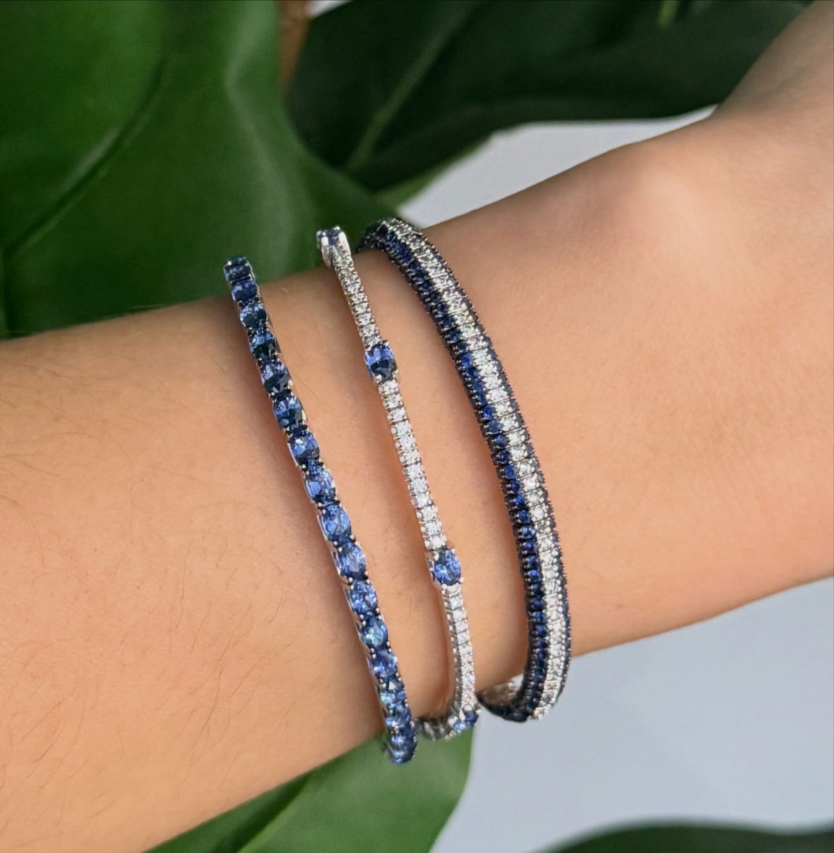 Blue sapphire and diamond bracelets stacked on the wrist