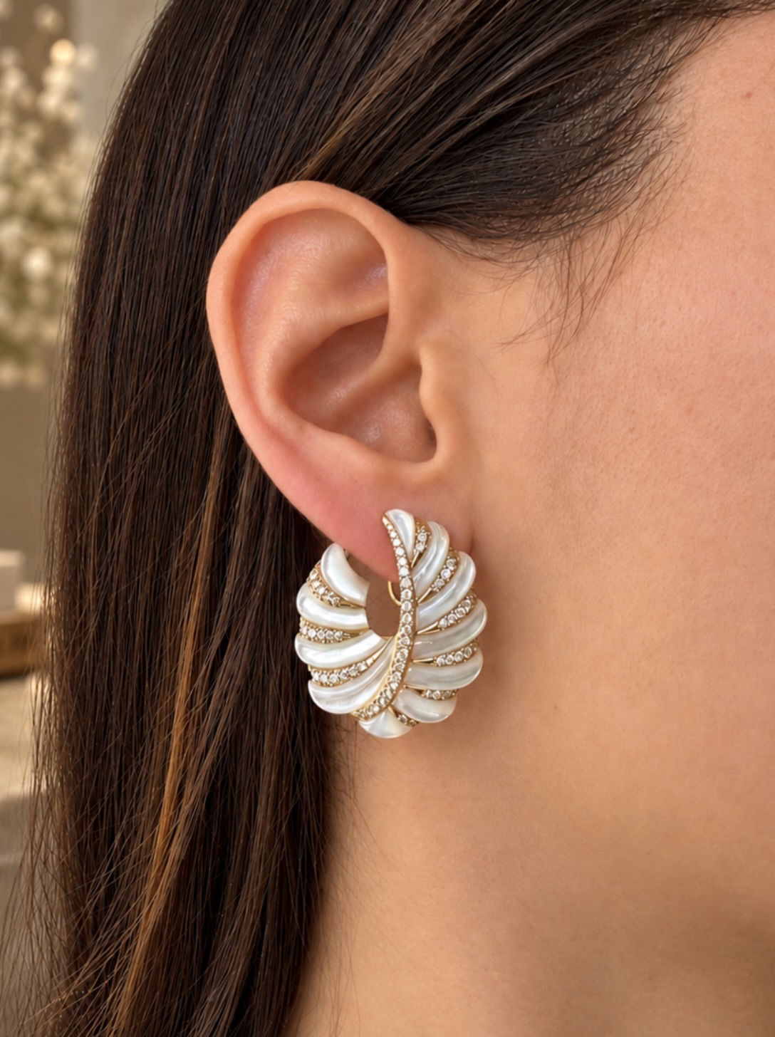 A carved white earring set with diamonds