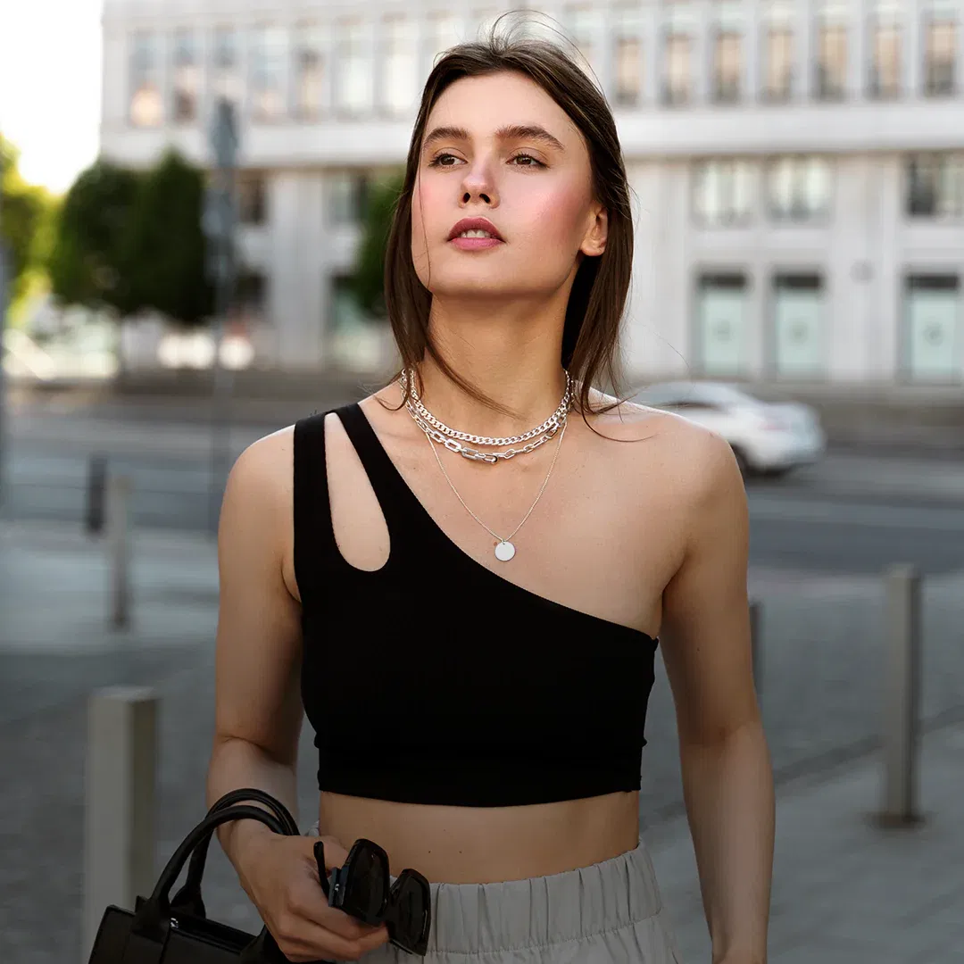 Layered fine gold necklaces on a soft neutral background