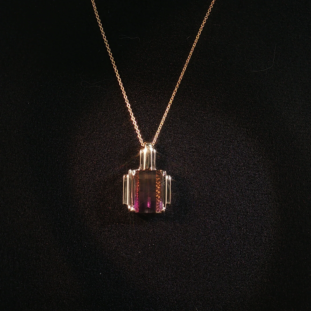 Layered fine gold necklaces styled on a neutral background