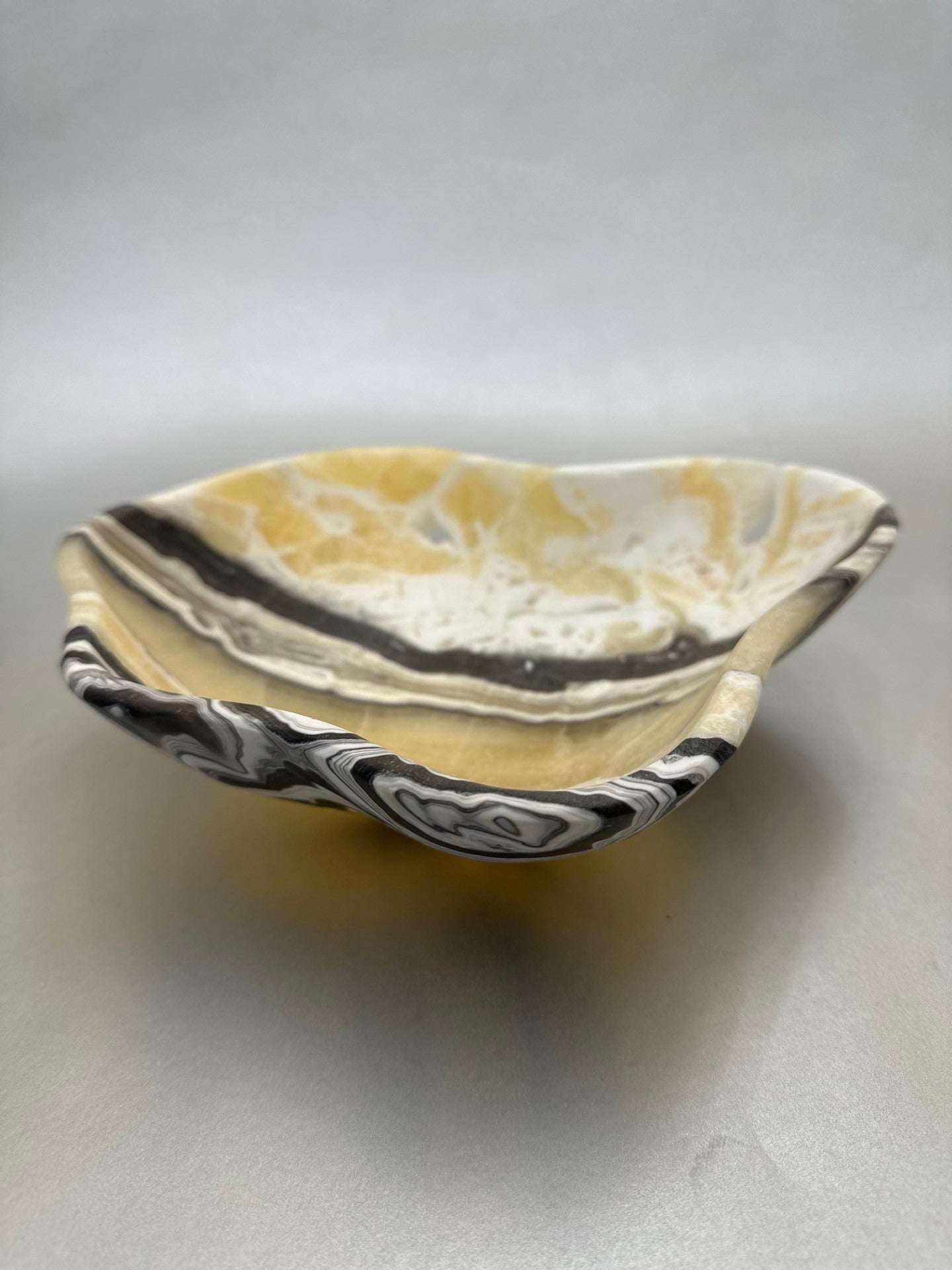 The 10" x 9" Free-Form Zebra Bowl is an exquisite statement piece, an eye-catching addition to any interior design. Whether serving your favorite snacks or adding a unique flair to your living space, this bowl is sure to ignite conversation with its bold, yet delicate curves. Free-Form Zebra Bowl
