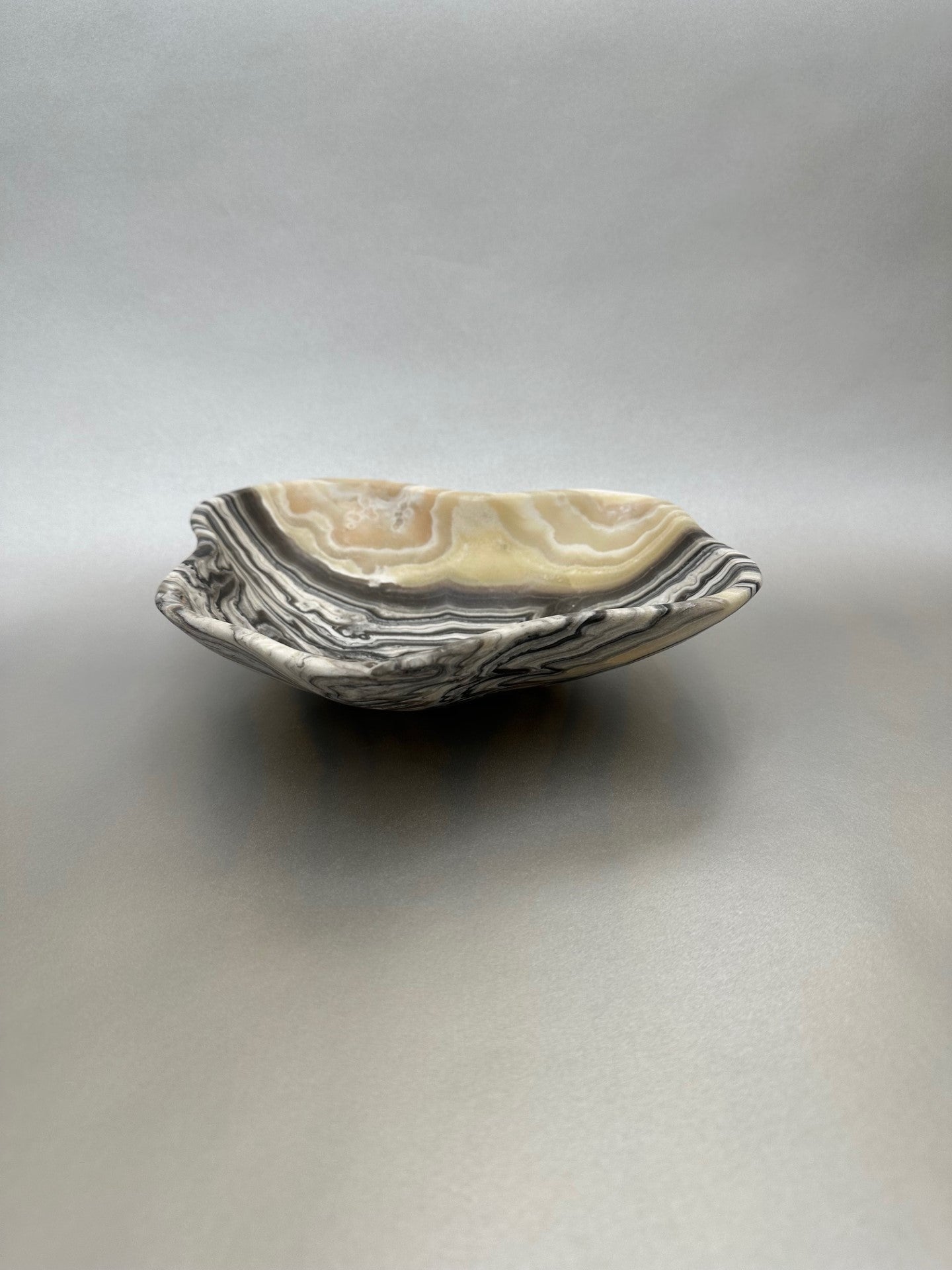 The 10" x 8.5" Free-Form Zebra Bowl is an exquisite statement piece, an eye-catching addition to any interior design. Whether serving your favorite snacks or adding a unique flair to your living space, this bowl is sure to ignite conversation with its bold, yet delicate curves. Free-Form Zebra Bowl