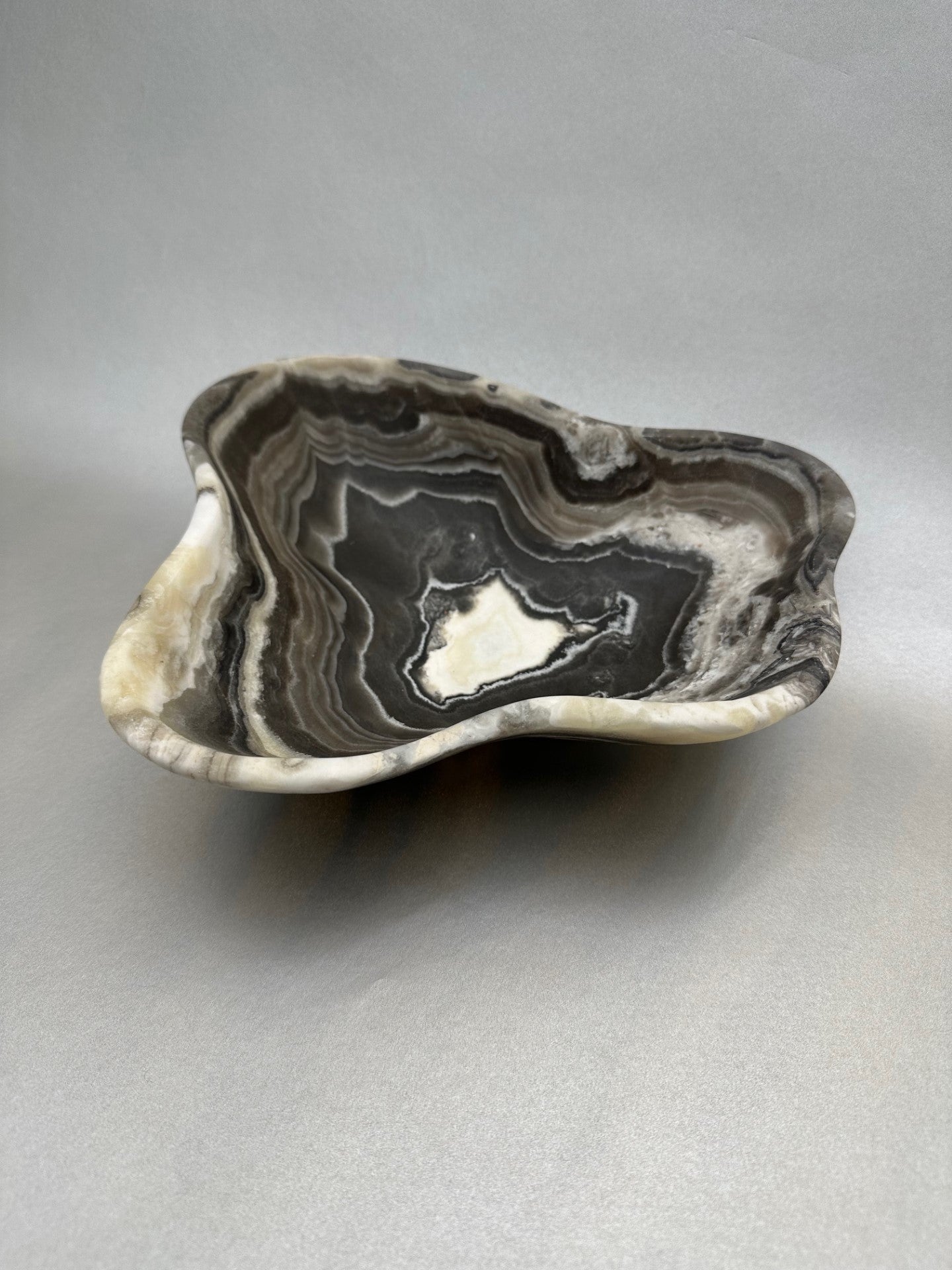The 8" x 8" Free-Form Zebra Bowl is an exquisite statement piece, an eye-catching addition to any interior design. Whether serving your favorite snacks or adding a unique flair to your living space, this bowl is sure to ignite conversation with its bold, yet delicate curves. Free-Form Zebra Bowl