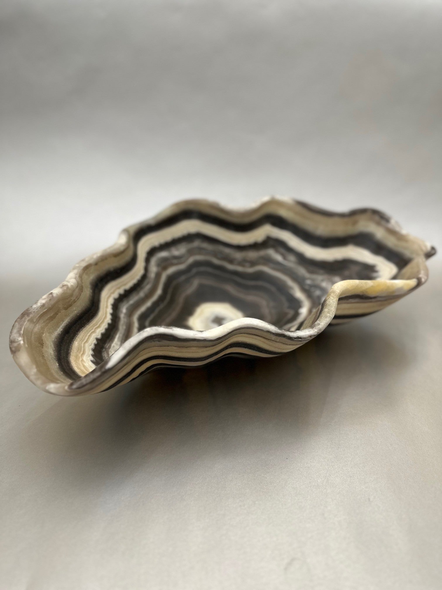 Adorn your space with this luxurious Medium Zebra Onyx Bowl, measuring 10"x17"x5". Its intricate black-and-white pattern is a work of art, sure to make a bold and distinguished statement in any room. Medium Zebra Onyx Bowl