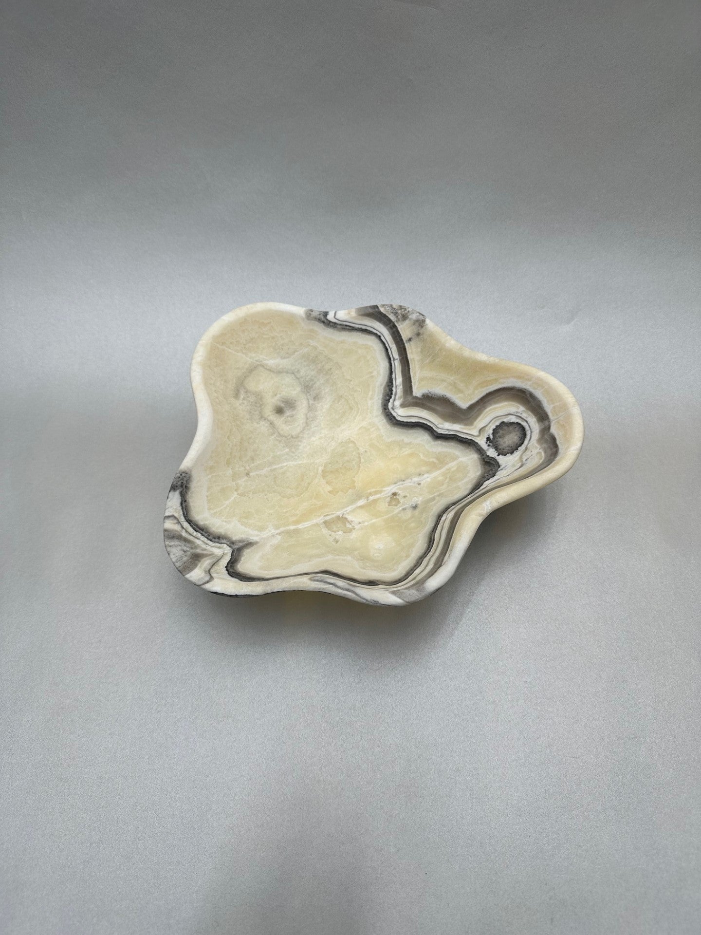 The 8.75" x 7.75" Free-Form Zebra Bowl is an exquisite statement piece, an eye-catching addition to any interior design. Whether serving your favorite snacks or adding a unique flair to your living space, this bowl is sure to ignite conversation with its bold, yet delicate curves. Free-Form Zebra Bowl