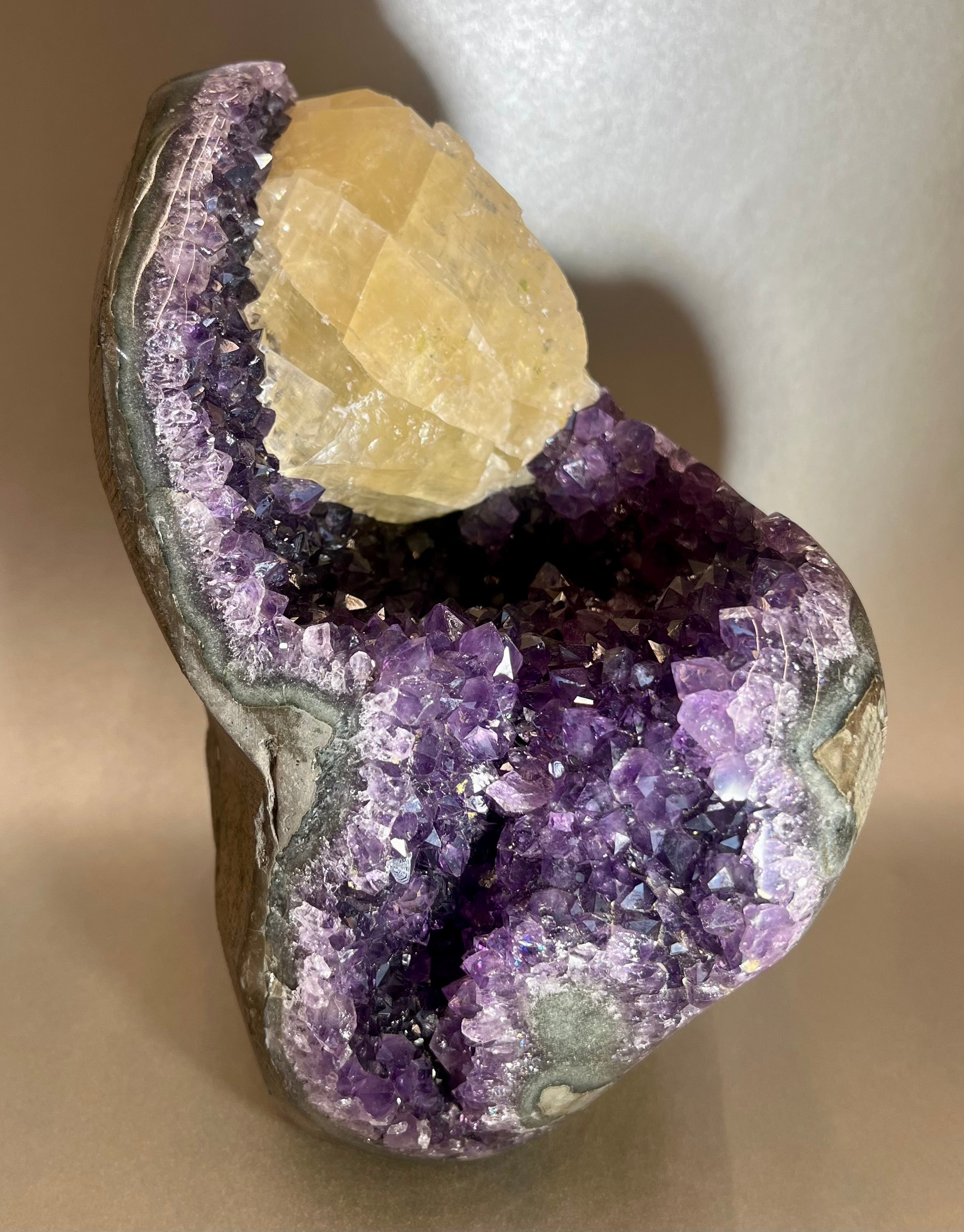 This luxurious Amethyst Freeform exudes elegance and exclusivity. Hand-crafted from amethyst found only in Brazil, it is a stunning addition to any space. Its free-standing design adds a touch of sophistication, while the natural properties of amethyst bring calm and balance. A truly exquisite piece for the discerning collector. (Approx. 3"W x 6"H) Amethyst Freeform