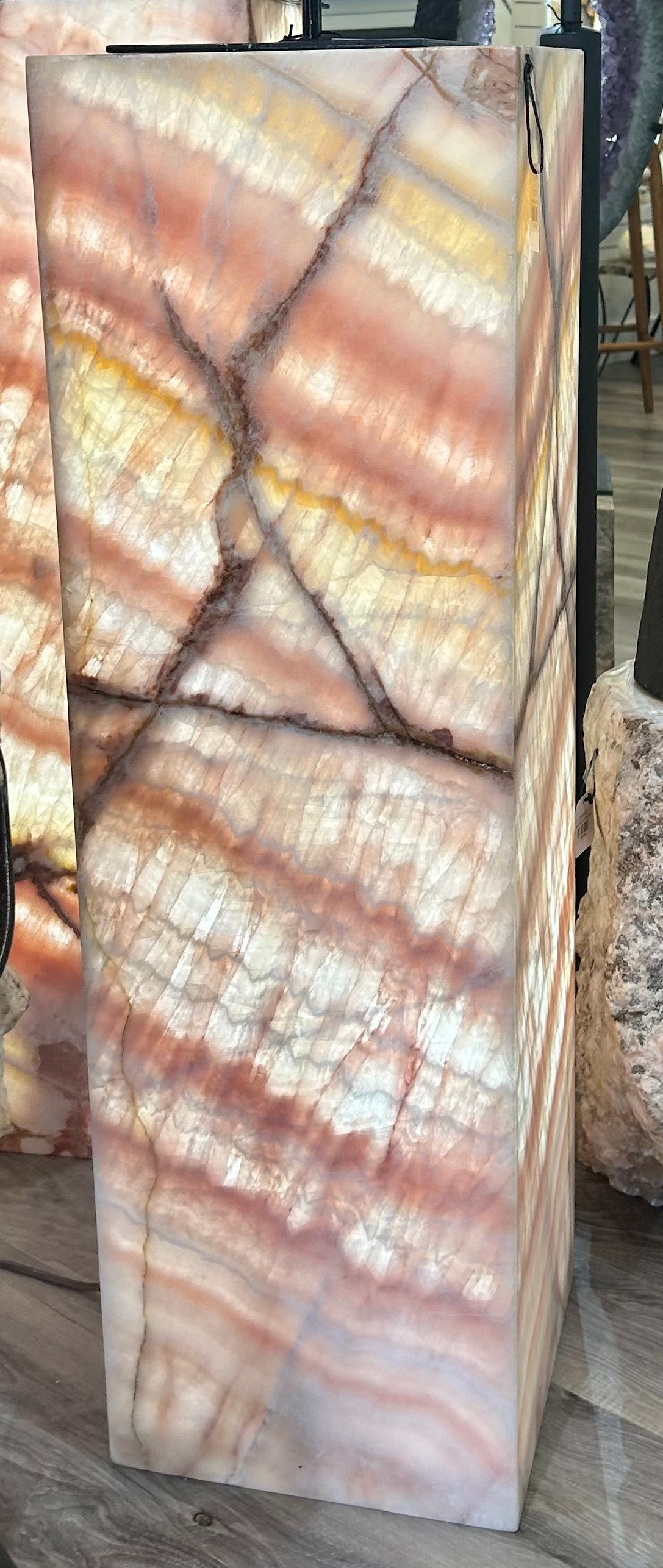 Elevate your home decor with the Rose Onyx Column. The warm glow from the column will create a mesmerizing ambience, perfect for a cozy night in. Enhance your living space with this exquisite piece, a true masterpiece of modern art.Measures approx. 12"W x 39"H. Rose Onyx Column